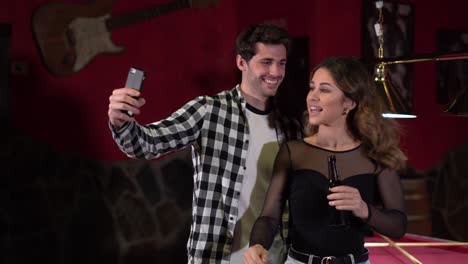 delighted couple taking selfie in bar