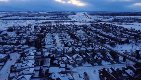 Fliegen-Sie-über-Ein-Friedliches-Winterwunderland,-Während-Der-Himmel-Dämmert-Und-Der-Schnee-Die-Nachbarschaft-Bedeckt