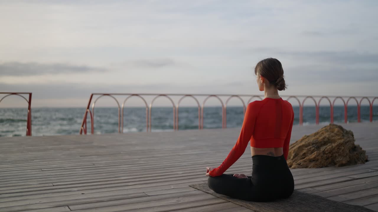 mujer meditando junto al océano