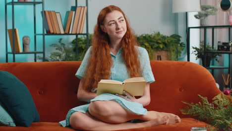 mujer joven relajándose libro interesante volteando páginas sonriendo disfrutando de la literatura descansando en el sofá