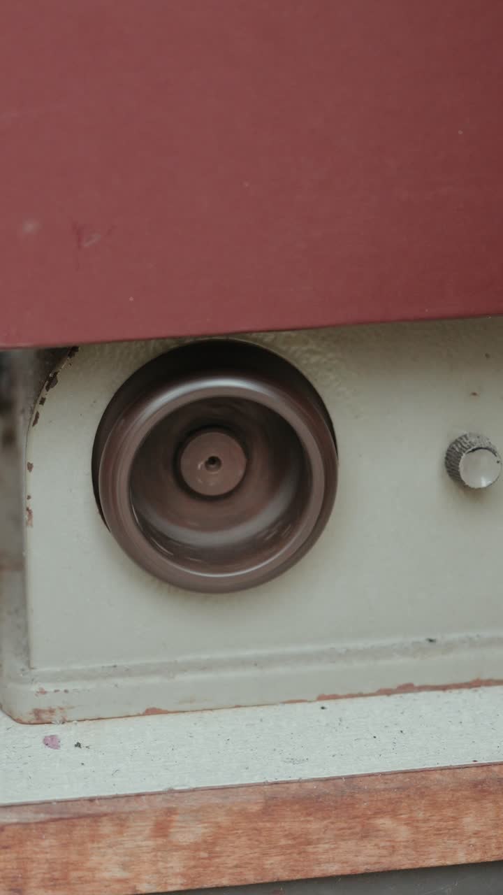 Vertical detailed shot of metal pulley spinning in mechanical equipment