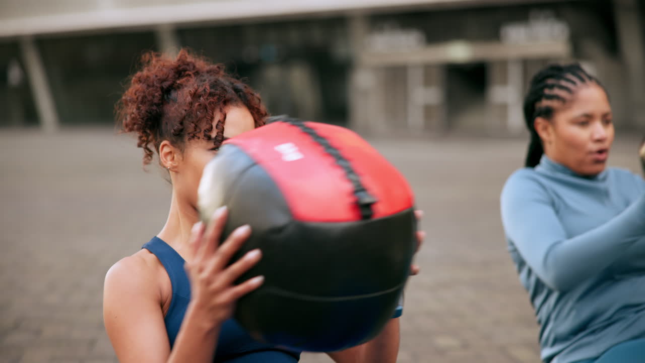 dos mujeres trabajando con bolas de medicina al aire libre