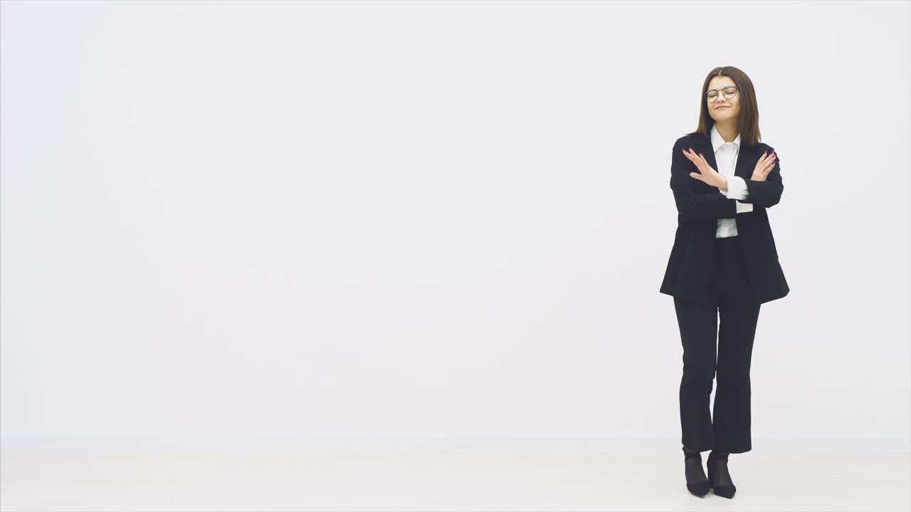 전체 길이의 매력적인 사업가 여성은 팔을 접고 서서, 진지하고 자신감을 가지고, 포즈를 취합니다.