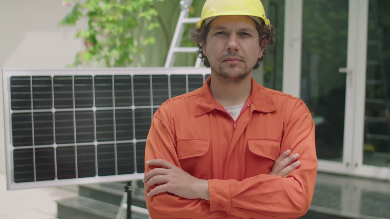Technician Posing Beside Solar Panel in Front of House