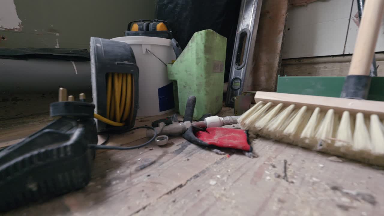 Bathroom renovation; close up tracking shot across stripped back room full of DIY tools during daytime