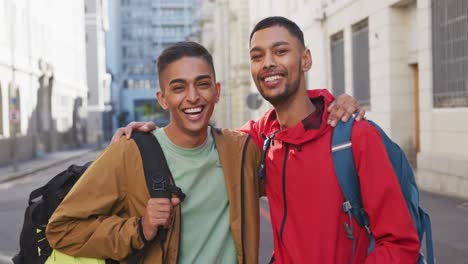 feliz pareja masculina gay de raza mixta abrazándose en la calle