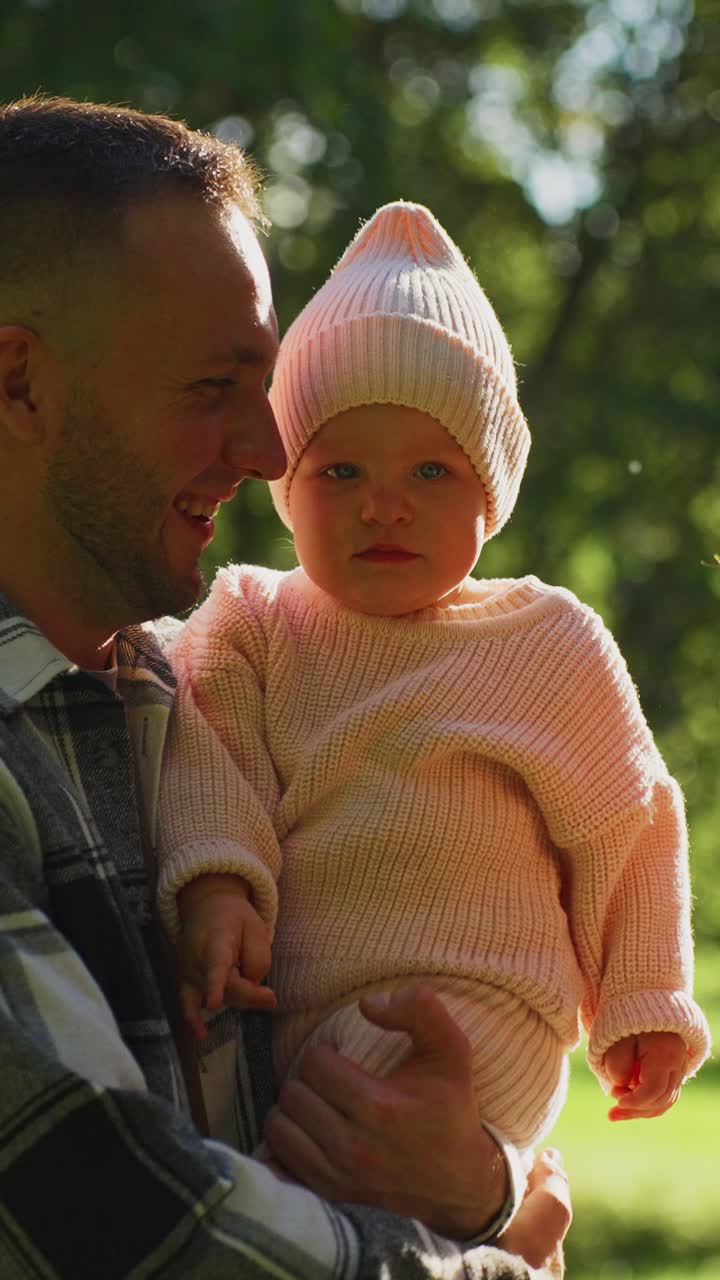 Genitori amorevoli che tengono in braccio il loro bambino in un parco soleggiato
