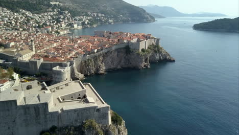 Luftaufnahme-Der-Altstadt-Von-Dubrovnik,-Die-Kamera-Fährt-Hoch-über-Die-Festung-Lovrijenac-Und-Weiter-In-Die-Altstadt