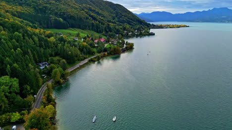 aerial dolly para a frente tirado sobre rota cênica através da noruega com floresta verde e pequena cidade ao longo da costa do fiorde