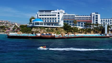 a couple crosses the sea in front of the hotel by jetski