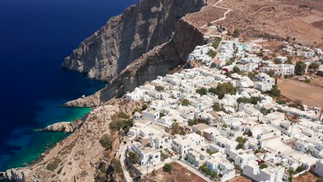 flying backwards tilt up shot reveal epic folegandros island, village and hilltop famous church