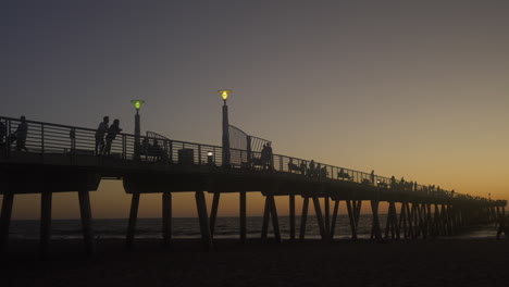 wide shot silhouette of hermosa pier at sunset