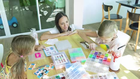 mother and daughters having fun with beading activity