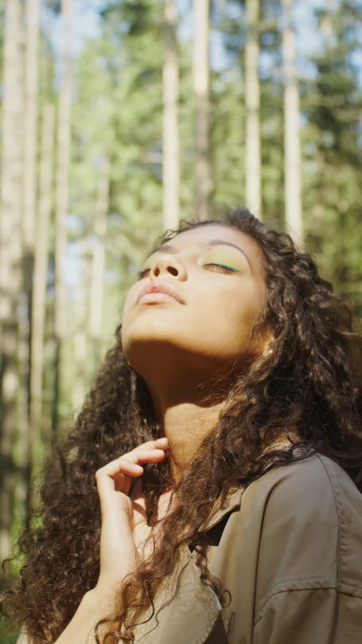 Portrait of a woman with curly hair in a forest