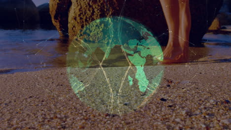 animation of globe and connections over legs of caucasian woman walking on beach