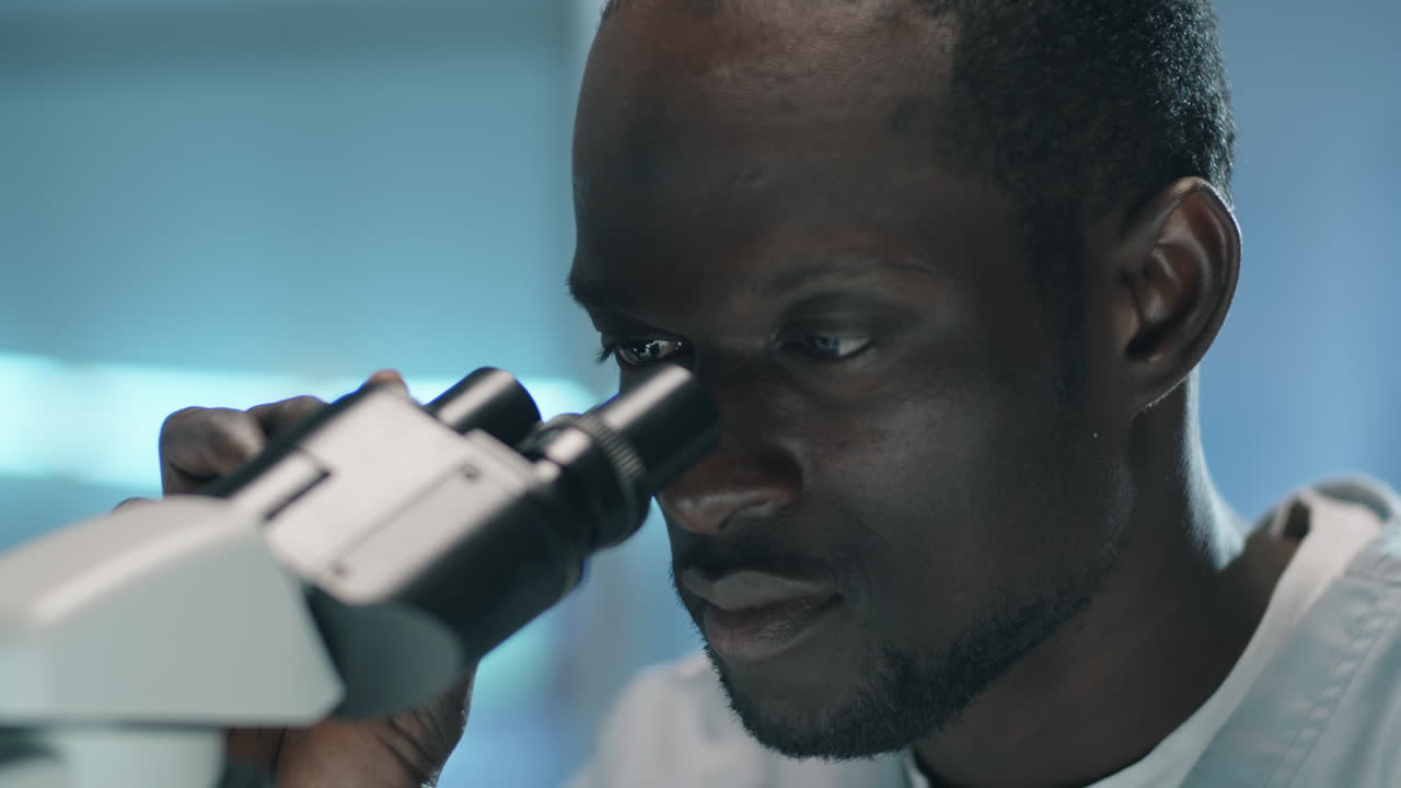 Black Scientist Using Microscope in Lab
