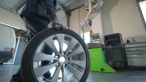 hands of mechanic with tool, changing tyre of car at auto service