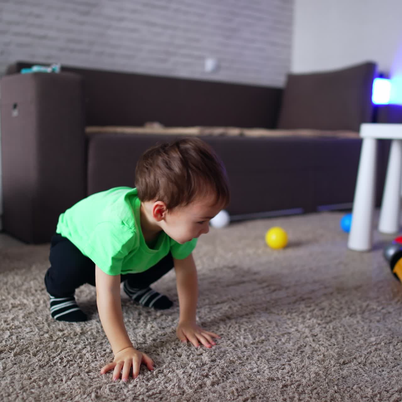 Bambino adorabile e allegro che gattona sul pavimento. Bambino felice che gioca nella sua stanza a casa