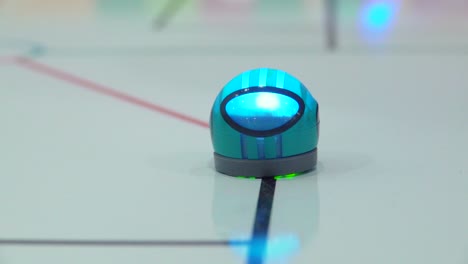 small teal robot on a playmat