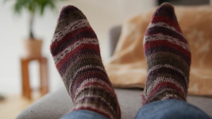 Piedi con calze calde di lana, calze a maglia a righe.