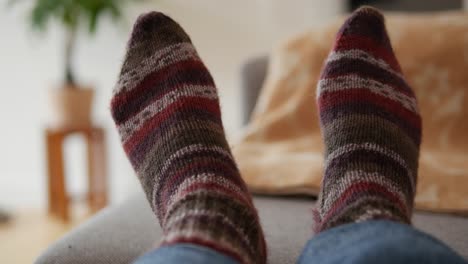 feet with warm, woolen socks on, striped knitted socks