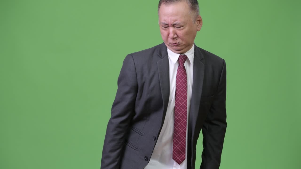 성숙 한 일본인 사업가 가 초록색 배경 에 는 것