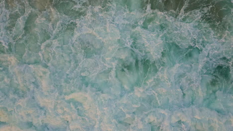 dynamic power ocean waves churning in sea aerial view. ocean swirls of foam