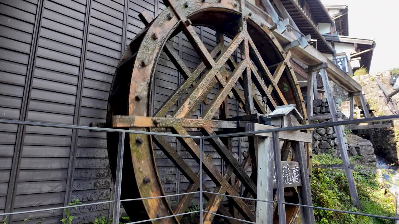 Traditional wooden water wheel located in the historical town of Magome-juku, Japan. Surrounded by iconic architectural styles, captures the blend of technology and nature in a peaceful environment.