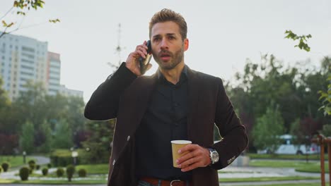 businessman talking on phone and holding coffee