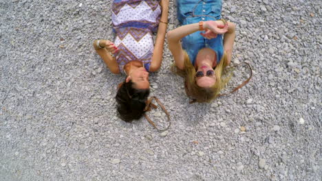 Two-friends-lying-on-a-gravel-dirt-road-together