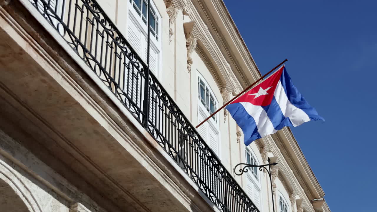 bandera cubana unida a la barandilla de un edificio en la habana