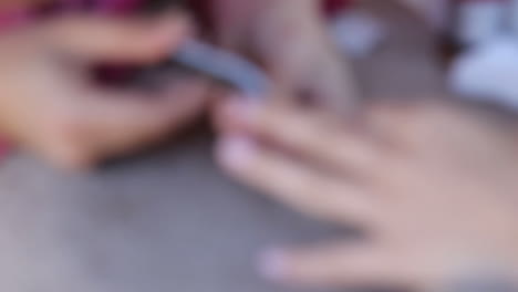 una mujer haciendo una manicura en un salón de uñas.