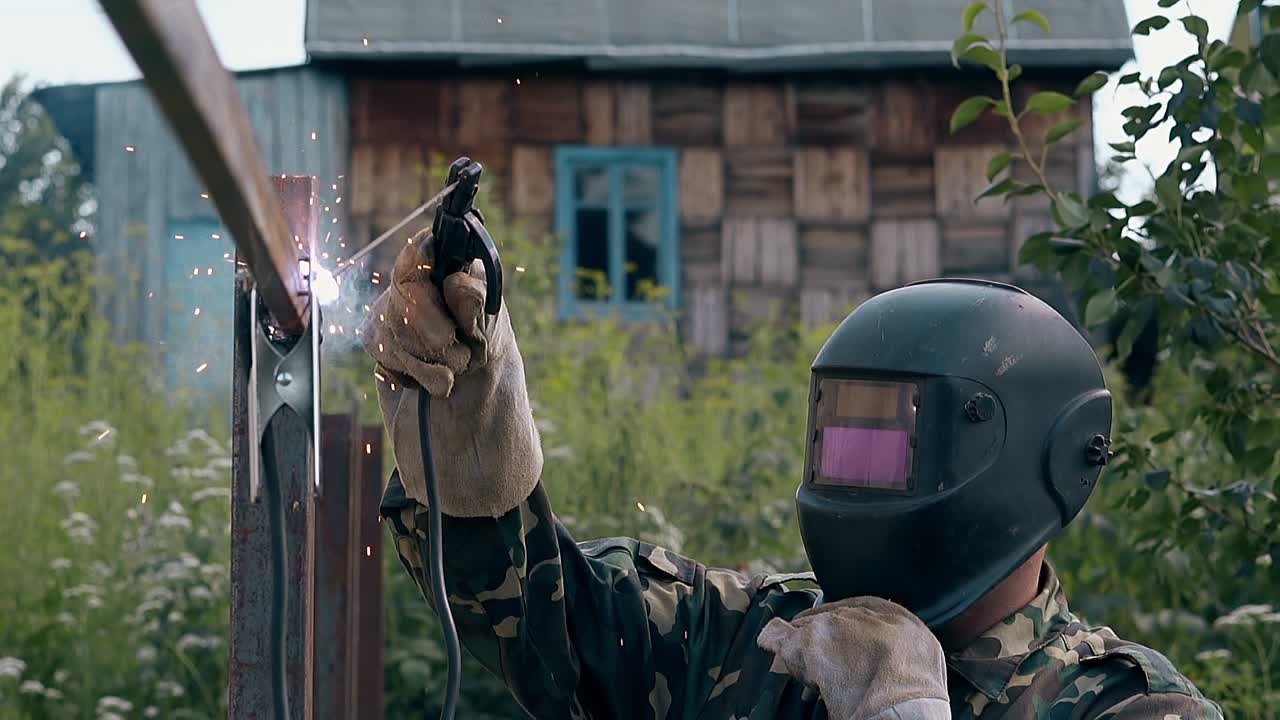 замедленный боковой вид мастер сваривает тушу ограды