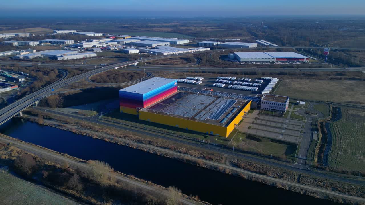 panorama of logistics center and distribution warehouse serving the drugstore chain, positioned next to a canal and highway infrastructure. Unbelievable aerial view drone top down Above view