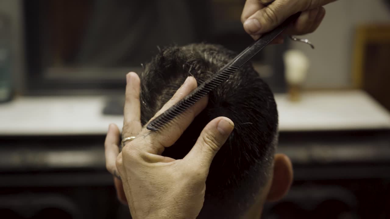 Close Up Of Barber Cutting Client's Hair At Barbershop
