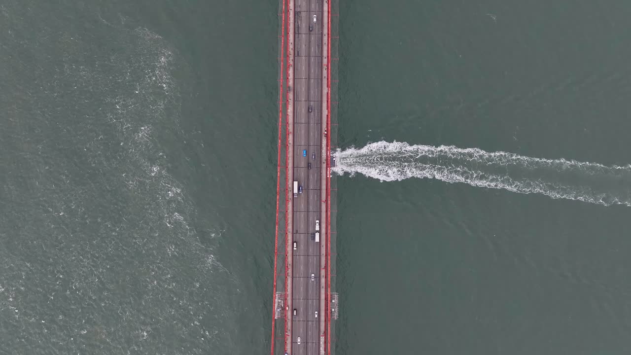 Passenger ferry sails across Golden Gate strait under highway on suspension bridge
