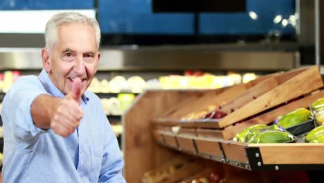 senior man picking out apples in supermarket