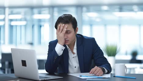 upset indian businessman slapping his head