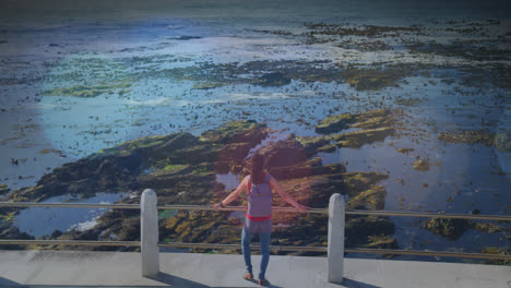 animación de puntos de luz sobre mujer biracial admirando la vista en el paseo marítimo