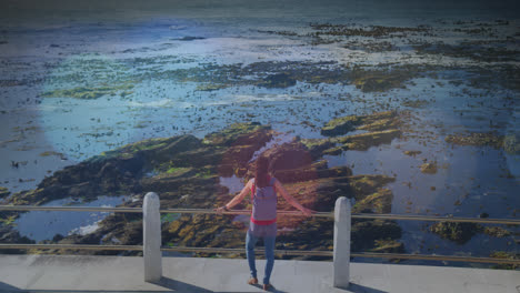 animation of light spots over biracial woman admiring view on promenade