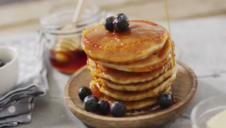 video of pancakes on plate seen from above on wooden background