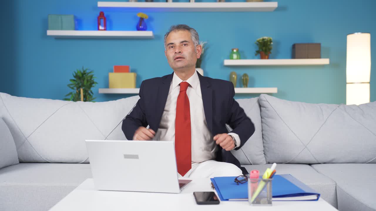 홈 오피스 직원 남자가 카메라를 향해 자만스럽게 쳐다보고 있습니다.