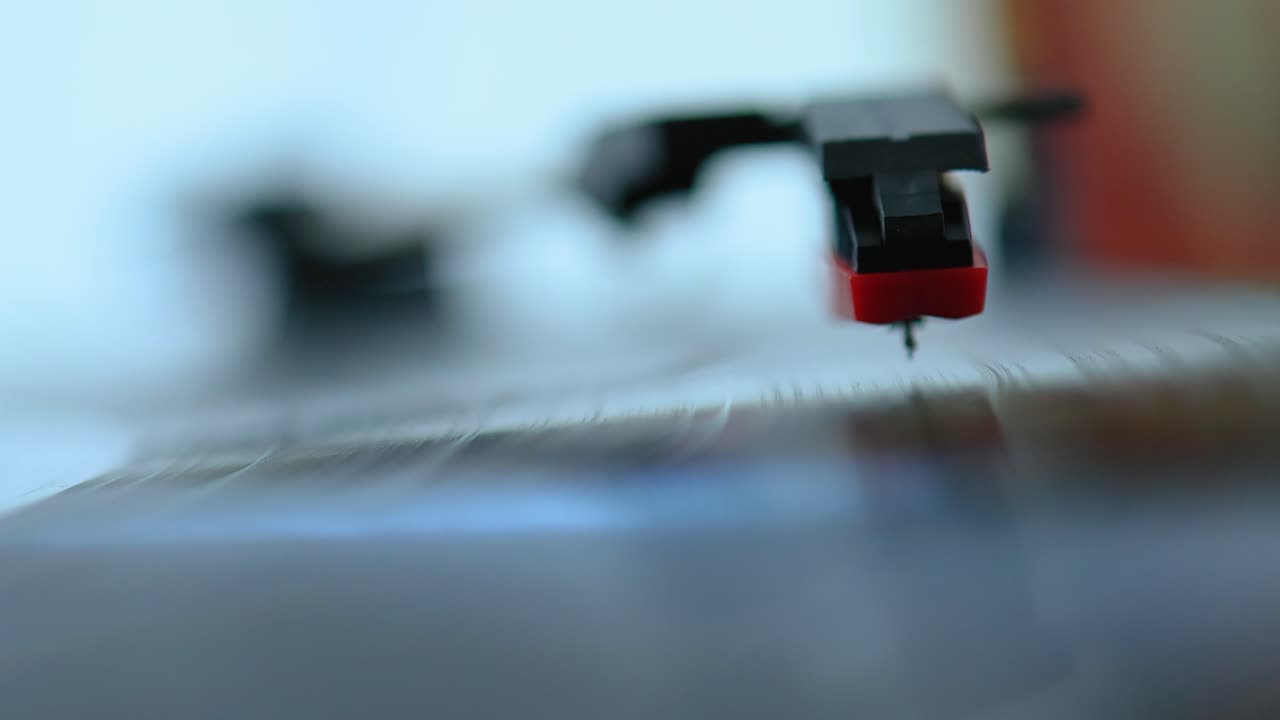 오래된 레코드 플레이어 위에 있는 비닐 표면에 바늘을 놓는 것