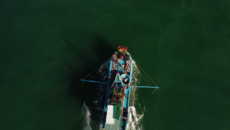 aerial birdseye tracking shot of fisherman boat going out in mui ne, vietnam