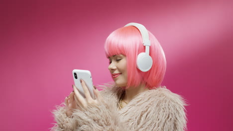 portrait of pretty woman wearing a pink wig and headphones