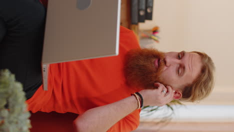 man sitting on home couch, looking at camera, making video conference call with friends or family