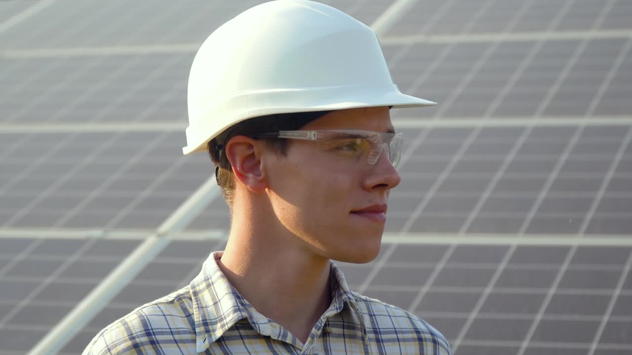 Engineer in a white helmet is at the solar power station