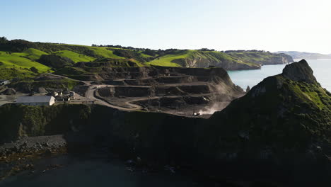 New-Zealand-quarry-on-coastline-of-Pacific-ocean,-aerial-orbit-view