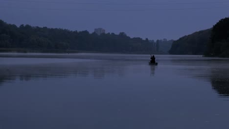 a man floats in a boat on the river at dusk. horror.