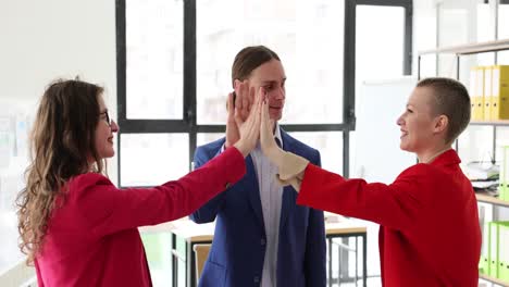 business colleagues celebrating success with high fives in office